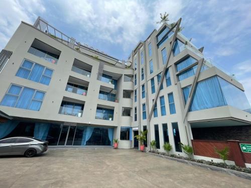 a building with a car parked in front of it at Ensuite studios luxury apartment Pool and balcony in Accra