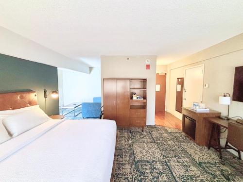 a hotel room with a bed and a desk at Four Points by Sheraton Norwood Conference Center in Norwood