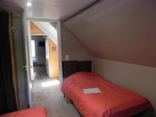 a small bedroom with a red bed in a attic at VILLA LOZELOUX n 2 in Le Mont-Dore