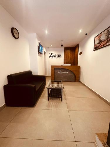 a living room with a couch and a table at ZAHIR RESIDENCY calicut in Kozhikode