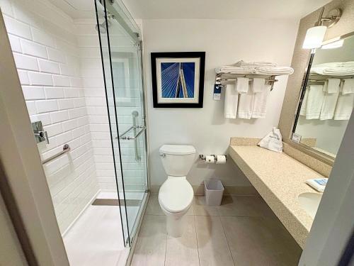 a bathroom with a toilet and a glass shower at Four Points by Sheraton Norwood Conference Center in Norwood