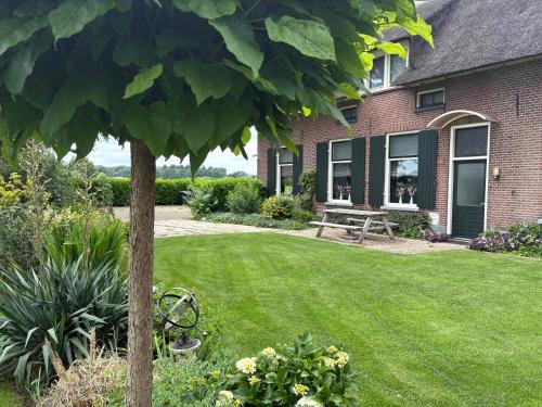 a house with a lawn and a picnic table at Vakantiehuisje Mesland-Loarne in Laren