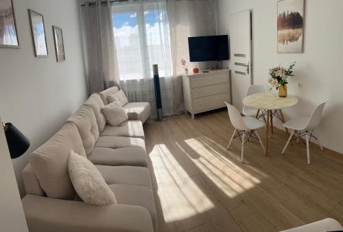 una sala de estar con un sofá y una mesa en Mieszkanie blisko morza Gdańsk Stogi, en Gdansk