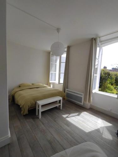 a bedroom with a bed and a large window at Charmant appartement Pornic in Pornic