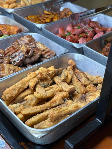a buffet of different types of food in trays at Chapada Park Pousada e Restaurante in Chapada dos Guimarães