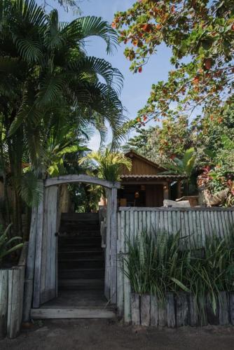 Una puerta de madera con escaleras que conducen a una casa. en Cabana Rio Caraiva, en Caraíva