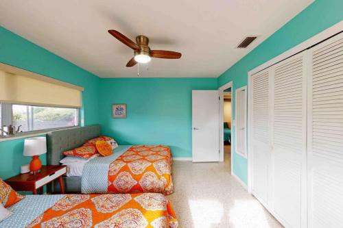 Un dormitorio con una cama y un ventilador de techo. en Vibrant Beach House-more units also available, en St Pete Beach