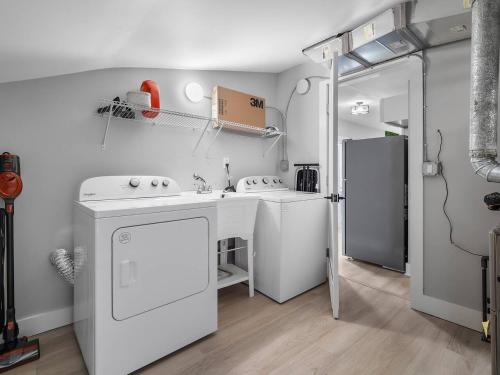 una cucina bianca con lavello e frigorifero di Amazing Boho Oasis Apartment in Ohio City a Ohio City