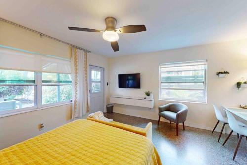 1 dormitorio con cama amarilla y ventilador de techo en Vibrant Beach Studio 1-more units also available, en St Pete Beach