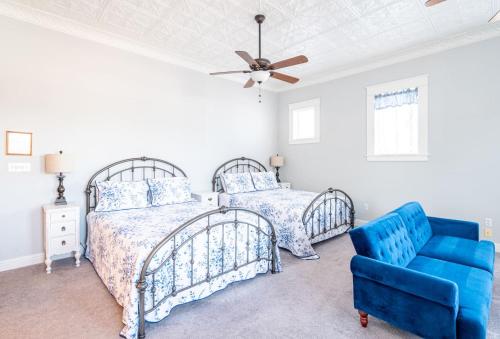 a bedroom with two beds and a blue chair at The Dallas Apartment in Eastland