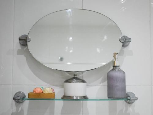 une étagère en verre avec un miroir et une bouteille dessus dans l'établissement 2bed Seafront Flat Private roof terrace Parking, à Southsea