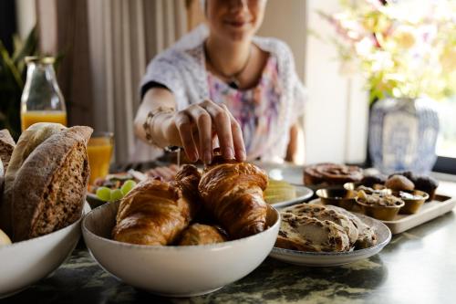 a woman is reaching for a plate of food on a table at Boutique Hotel Charley's in Westkapelle