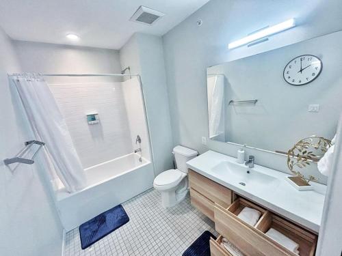 a bathroom with a sink and a clock on the wall at Cloud Nine Studio in Des Moines