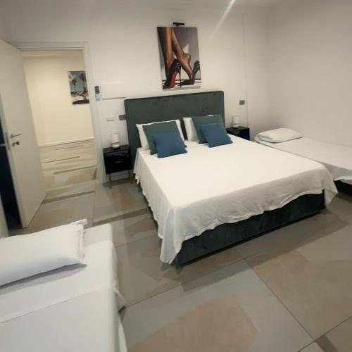 a bedroom with a large white bed with blue pillows at Crazi Suites in Nola