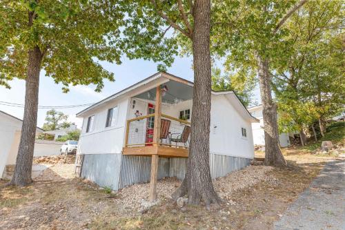 ein Haus mit einer Veranda inmitten von Bäumen in der Unterkunft Historic Rockaway Beach Cottage 7 in Rockaway Beach