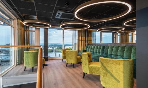 a waiting room with green chairs and windows at Thon Hotel Panorama in Oslo