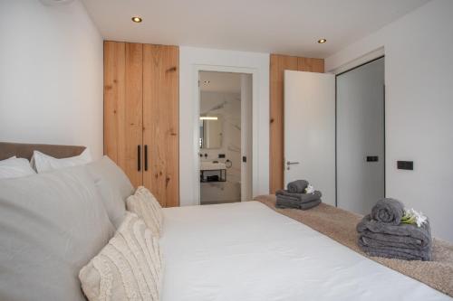 a bedroom with a white bed with towels on it at Zon&zo Luxurious Apartment in Jan Thiel in Jan Thiel