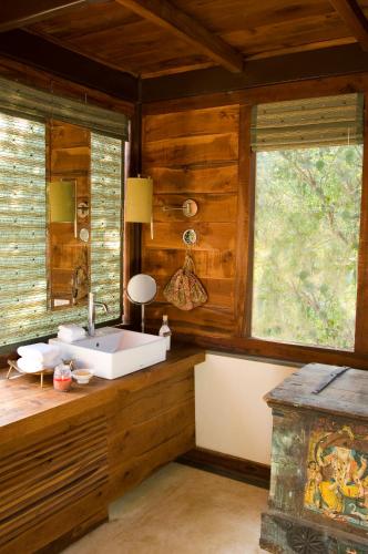 a bathroom with a tub in a room with wooden walls at Baghvan Pench National Park - A Taj Safari Lodge in Behrai