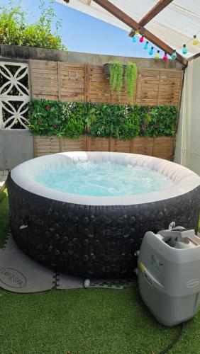 einen Whirlpool im Garten mit Grill in der Unterkunft L'orchidée de kinabalu in Cabassou