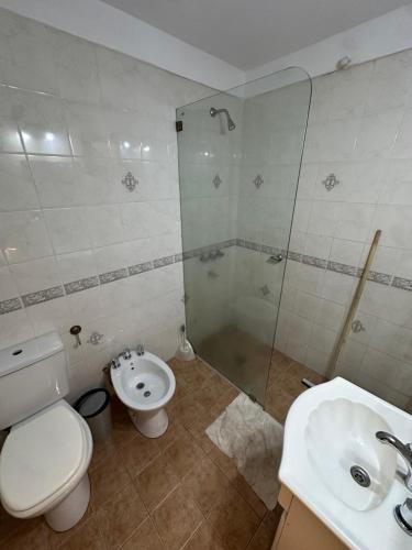 a bathroom with a toilet and a shower and a sink at El refugio in Villa del Dique