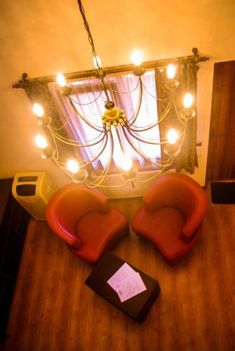 a room with a chandelier and chairs on the floor at Hanul Fullton in Cluj-Napoca