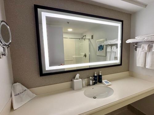 a bathroom with a sink and a mirror at Four Points by Sheraton Norwood Conference Center in Norwood