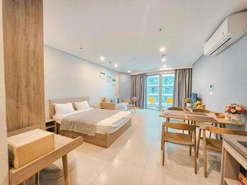 a hotel room with a bed and a dining room at Sóng Homestay-The Sóng Apartment Vũng Tàu Nghỉ Dưỡng Biển Cao Cấp 5 Sao- The Song Vung Tau Condotel 5 Star Beach View Apartment in Vung Tau