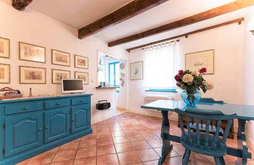 a kitchen with a table and a vase with flowers on it at Alguerhome Casa Turchese old town in Alghero