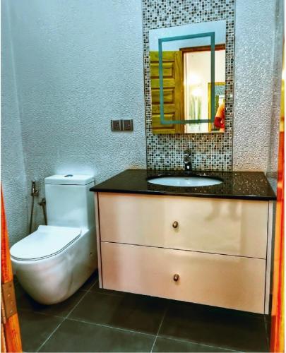 a bathroom with a sink and a toilet and a mirror at Regus Jaffna in Jaffna