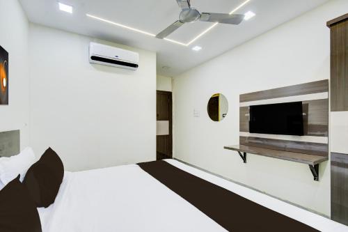 a bedroom with a bed and a flat screen tv at Hotel O Vijaya Grand in Pedda Ambarpet