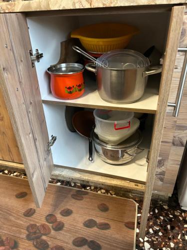 a cabinet with some pots and pans in it at ''Mary's House'' Entire residence Olympiada Halkidiki Near to Sea 200m ! in Olympiada