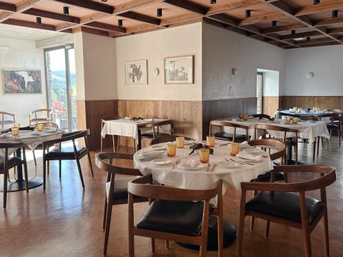 a restaurant with tables and chairs in a room at Soadro do Zêzere - Hotel Rural e Restaurante in Valhelhas