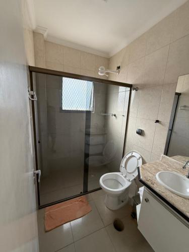 a bathroom with a shower and a toilet and a sink at Cobertura Hidro Spa com Espaço Gourmet Churrasqueira in Guarujá