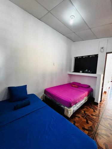 a room with two beds and a flat screen tv at LA CASONA SV Hostal in La Libertad
