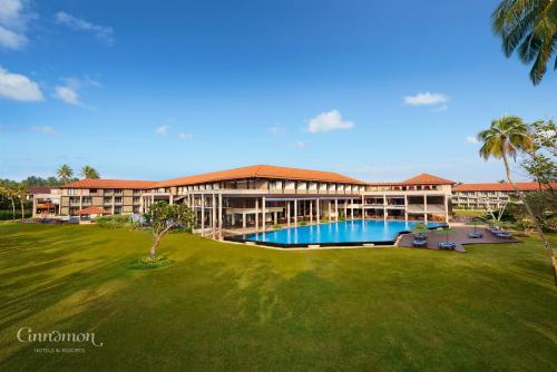 a resort with a large building with a swimming pool at Cinnamon Bey Beruwala in Bentota