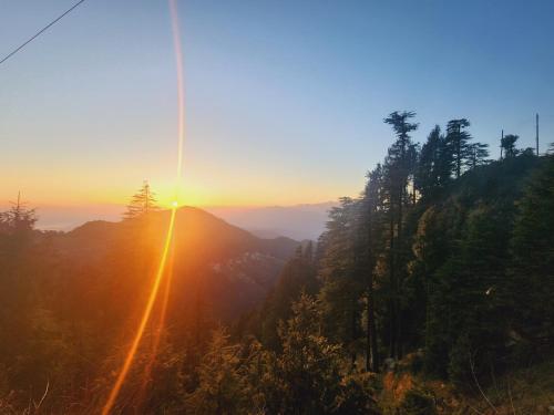 a view of the sun setting over a mountain at Greenvalley View in Dalhousie