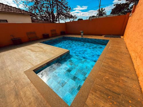 una piscina con agua azul en un patio trasero en Chalé Hotel, en Piratininga