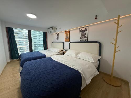 深セン市にあるSpark Hotel & Serviced Apartmentsのベッドルーム1室(青と白のシーツが備わるベッド2台付)