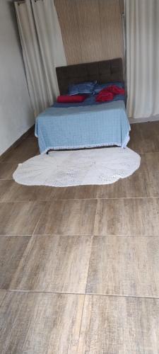 una camera da letto con un letto e un pavimento in legno di Casa da SU no meio da natureza a Bueno Brandão