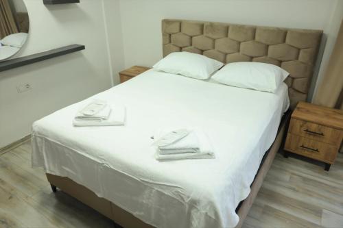 a bed with white sheets and towels on it at lamoza in Narlıdere