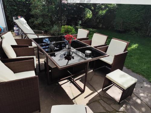 a glass table and chairs on a patio at Elegantes Haus, Bikes, ruhig, Garten, Seenähe, ab 6 Jahre in Starnberg