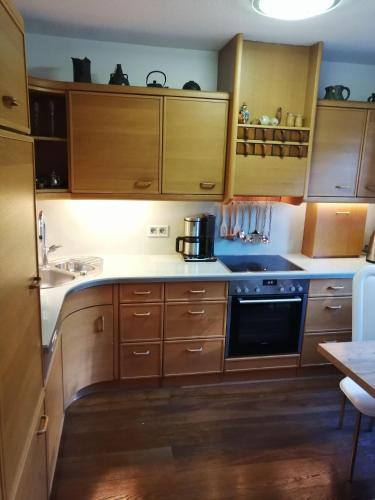 a kitchen with wooden cabinets and a stove top oven at Elegantes Haus, Bikes, ruhig, Garten, Seenähe, ab 6 Jahre in Starnberg