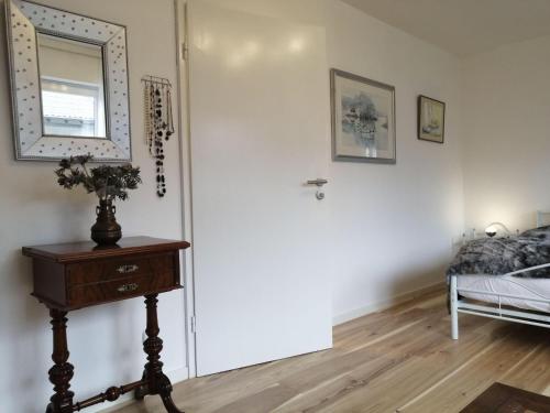 a room with a bed and a table and a mirror at Elegantes Haus, Bikes, ruhig, Garten, Seenähe, ab 6 Jahre in Starnberg