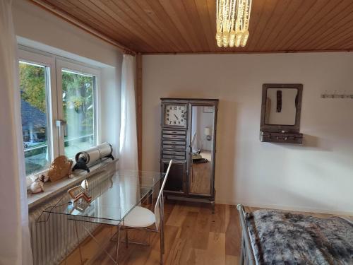 a room with a glass table and a clock on the wall at Elegantes Haus, Bikes, ruhig, Garten, Seenähe, ab 6 Jahre in Starnberg