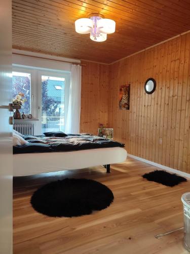 a bedroom with a bed in a room with wooden walls at Elegantes Haus, Bikes, ruhig, Garten, Seenähe, ab 6 Jahre in Starnberg