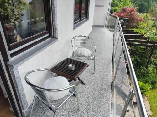 two chairs and a table on a balcony at Elegantes Haus, Bikes, ruhig, Garten, Seenähe, ab 6 Jahre in Starnberg