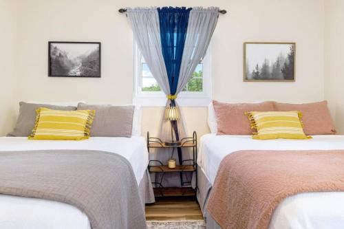 two beds in a room with a window at Cozy Apartment in Downtown Elizabethton in Elizabethton