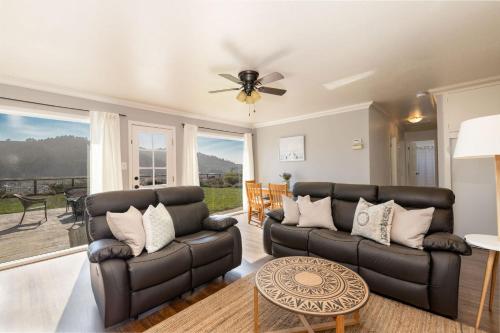 a living room with two couches and a ceiling fan at Entire Ocean View Home beaches hiking restaurants family activities in Pacifica