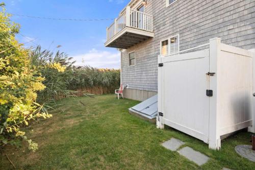 a backyard with a white door and a balcony at Stunning Home with Water Views in Sandwich