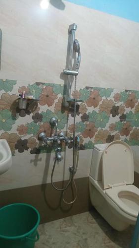 a bathroom with a shower and a toilet and flowers at Shalom in Trivandrum